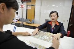 A banker conducts a gold bullion transaction with a customer at the Sacombank in Ho Chi Minh City, J