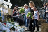 Children place flowers at a tribute at the entrance of the 't Stekske primary school in Lommel to the victims of a March 13 Swiss bus crash. The first survivors of the crash that shocked Belgium returned to a national day of mourning Friday, after grieving parents laid flowers at the Swiss Alps tunnel site where 22 school children died.