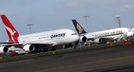 File photo shows a Qantas Airbus A380 (L) and a Singapore Airlines' A380 (R) at Sydney International Airport. Australian carrier Qantas and Singapore Airlines Friday reassured passengers there was no risk to safety after cracks were found on the wings of several A380 superjumbos, including some in their fleets