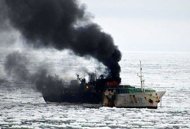 Photo released January 12, shows the burning Jeong Woo 2, a 51-metre-long Korean fishing vessel where three crew men appear to have been killed after a fire broke out on board. A US Air force cargo plane was to leave New Zealand late Thursday to evacuate seven crewmen injured in the fire