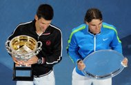 Novak Djokovic of Serbia (L) holds the winner's trophy as runner up Rafael Nadal of Spain holds his plate at the awards ceremony for the men's final match on day 14 of the 2012 Australian Open tennis tournament. Djokovic won the championship 5-7, 6-4, 6-2, 6-7, 7-5.