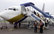 This file photo shows passengers boarding a plane of Mandala Airlines, in Medan, in 2005. Singapore budget airline Tiger Airways said on Monday it had bought a 33 percent stake in beleaguered Indonesian carrier PT Mandala Airlines as part of its regional expansion plans