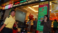 A body guard is pictured in front of the Mi Hong gold shop with the sign that reads 