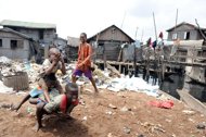 Children are seen playing next to waste in the Makoko slum in Lagos, in 2011. More than one billion children now live in crowded cities around the world but too many are stuck among the poorest of the poor without electricity, water or education, according to a UN report, released on Tuesday. 