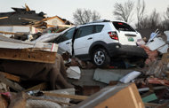 A vehicles sits in the debris of a home after a tornado ripped through a neighborhood in Harrisburg, Illinois. A deadly string of tornadoes cut a swath of destruction across the US midwest, killing at least 11 people and threatening scores more as a massive storm pushed eastward early Thursday. 