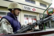 A Pakistani paramilitary soldier guards a branch of HSBC in Karachi in 2003. HSBC on Tuesday dismissed a report in the Financial Times which said the global banking giant plans to scale back or even exit certain Asian countries to concentrate on core areas