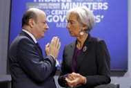 This file photo shows Poland's Finance Minister Jacek Rostowski (L) talking to IMF head Christine Lagarde before a meeting in Paris, in 2011. The IMF announced on Wednesday that Poland had pledged additional funding of about $8 billion to the global lender. 