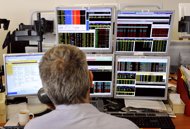 A trader looks at screens showing stock exchange share index in Paris, 2011. European stock markets rose and the euro gained against the dollar as investors looked ahead to a key IMF meeting and weekend French elections, and also kept watch over Spain.