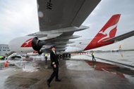 Qantas pilot, captain Richard de Crespigny, pictured under a Qantas Airbus A380 jet wing at the Changi International Airport in Singapore, on April 21. Airbus will pay to repair wing cracks in A380 superjumbos, but compensation is unlikely to extend to other costs such as the time the aircraft were out of service, according to reports