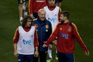 Spain coach Vicente del Bosque (C) talks to his players Carles Puyol and Gerard Pique (R) during a training session in February. Spain will become the first footballing nation to complete a hat-trick of major championships if Del Bosque's side retain their crown.