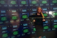 A television anchor stands in front of screens showing the start of trading in Facebook shares at the NASDAQ stock exchange. fell again in nervous trade on Friday and the euro hit a new four-month low against the dollar as ratings agencies further downgraded Greek and Spanish banks. (AFP Photo/Emmanuel Dunand)