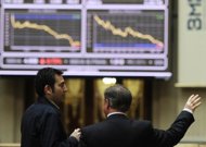 Men look at the IBEX-35 index curve on April 23 at Madrid's stock exchange. European shares dived and the euro hit a 22-month low on Wednesday before an informal EU summit and after the former Greek prime minister warned that Greece might leave the eurozone. 