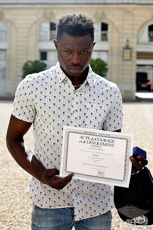 migrant spiderman who saved child praised by frances macron