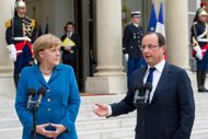French President Francois Hollande (R) and German Chancellor Angela Merkel speak to journalists before a working diner in Paris, on June 27. EU leaders debate 