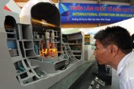 This file photo shows a visitor looking at a model of Japanese-made nuclear reactor model at an exhibition on nuclear power in Hanoi, in 2010. Tokyo Electric Power Co. is to abandon plans to export its nuclear power plant expertise as it struggles to cope with the Fukushima disaster, news reports said Thursday