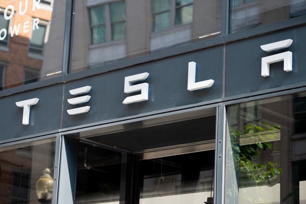 In this file photo the Tesla logo is seen outside of their showroom in Washington, DC, on August 8, 2018. Tesla scored record car deliveries in the second quarter, while Ford reported higher US auto sales despite a drag from the worldwide semiconductor shortage in June, the companies said July 2, 2021. SAUL LOEB / AFP
