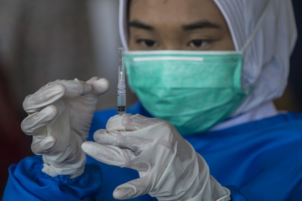 A health worker prepares a syringe with the Sinovac Covid-19 coronavirus vaccine during a vaccination drive for schoolchildren aged 12-18 in Surabaya on July 11, 2021, as Indonesia faces its most serious outbreak driven by the highly infectious Delta variant. Juni Kriswanto / AFP