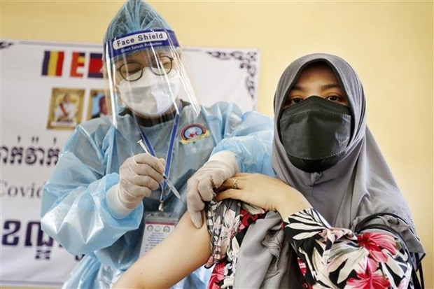A health worker admisters a shot of COVID-19 vaccine to a woman in Phnom Penh, Cambodia on July 2. (Photo: XINHUA/VNA)