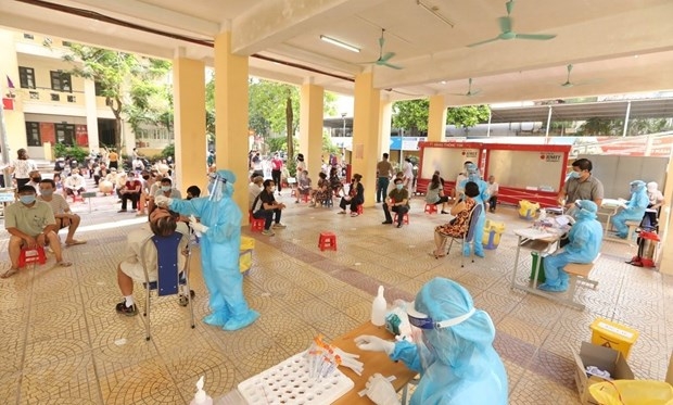 Medical staff in Hai Ba Trung district collaborate with Bach Mai ward's health workers to conduct COVID-19 testing for people in high-risk areas. (Photo: VNA)