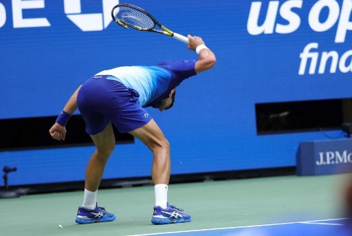 Novak Djokovic of Serbia smashes his racket in frustration while playing against Daniil Medvedev of Russia in the second set of the Men's Singles final match at the USTA Billie Jean King National Tennis Center in New York, on September 12, 2021. KENA BETANCUR / AFP
