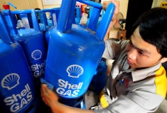 An attendant lifts a Shell Gas cylinder at a gas dealer on Nguyen Kem Street, Ho Chi Minh City