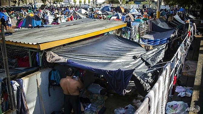 hundreds of migrants push on to us mexico border bridge