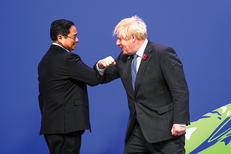 UK Prime Minister Boris Johnson (right) greets Vietnam’s Prime Minister Pham Minh Chinh at COP26