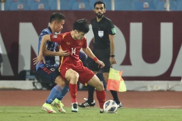 Players of Vietnam (in red) and Japan vie for the ball (Photo: VNA)