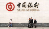 File photo of people walking past the Bank of China branch in Beijing. Chinese investors withdrew hundreds of billions of yuan from major banks in the first 10 days of December, state media said Friday, on falling expectations the currency will strengthen.