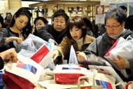 Shoppers are seen here at Tokyo's Mitsukoshi department store. The government said it expects prices to remain stable, projecting consumer prices to rise 0.1 percent in 2012, adding to the woes of companies that have long grappled with the damaging effects of deflation